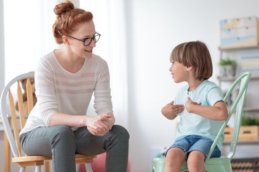 Erzieherin im Gespräch mit einem kleinen Jungen