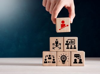 Hand, die eine Würfelpyramide aufbaut