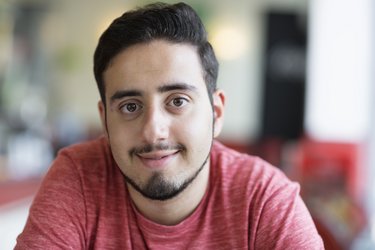 Portrait eines jungen lächelnden Mannes mit rotem T-Shirt