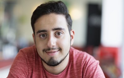 Portrait eines jungen lächelnden Mannes mit rotem T-Shirt