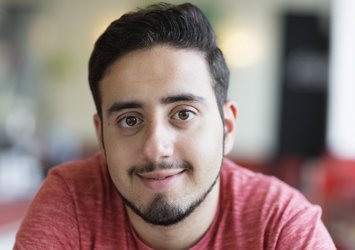 Portrait eines jungen lächelnden Mannes mit rotem T-Shirt