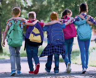 Schulkinder gehend, von hinten, einander umarmend