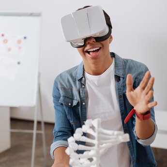 Auszubildender mit einer VR-Brille vor einer DNA-Spirale