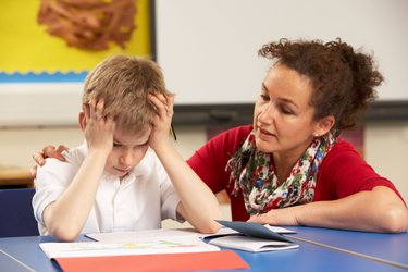 Weibliche Lehrkraft im Gespräch mit einem verzweifelten Schüler
