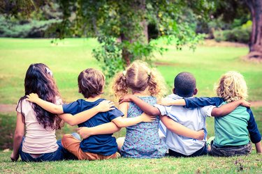 Kindergartenkinder von hinten, die einander umarmen