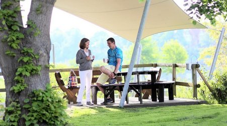 Außengelände der IBAF-Zentrale mit Janett Friese im Gespräch mit einem Teilnehmenden