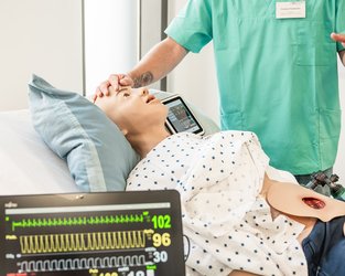 Im SkillsLab steht eine Lehrkraft an einem Simulator und zeigt die Funktionen.