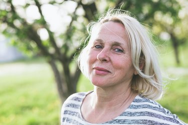 Mittelalte blonde Frau, die in die Kamera lächelt